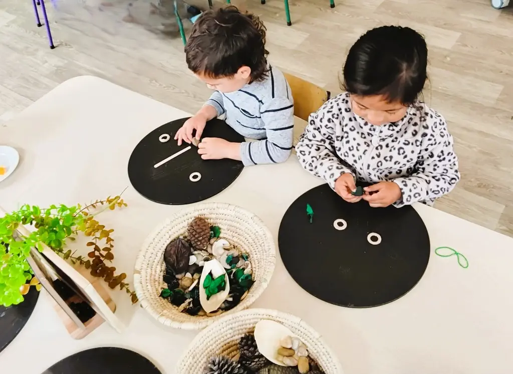 Children arranging loose parts to make faces