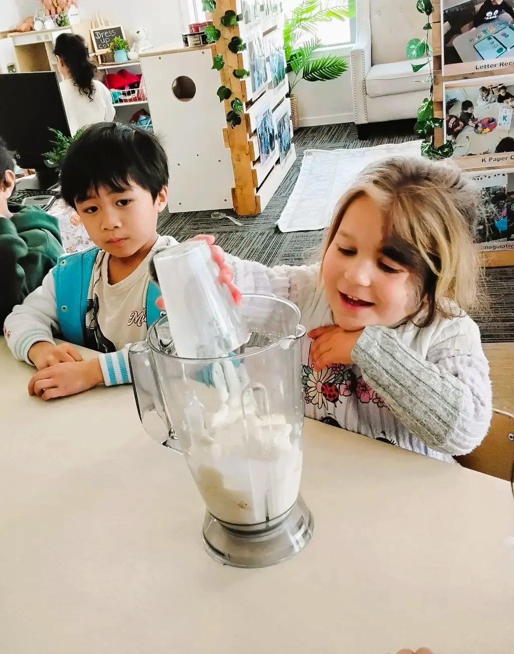 Children measuring ingredients beside a blender