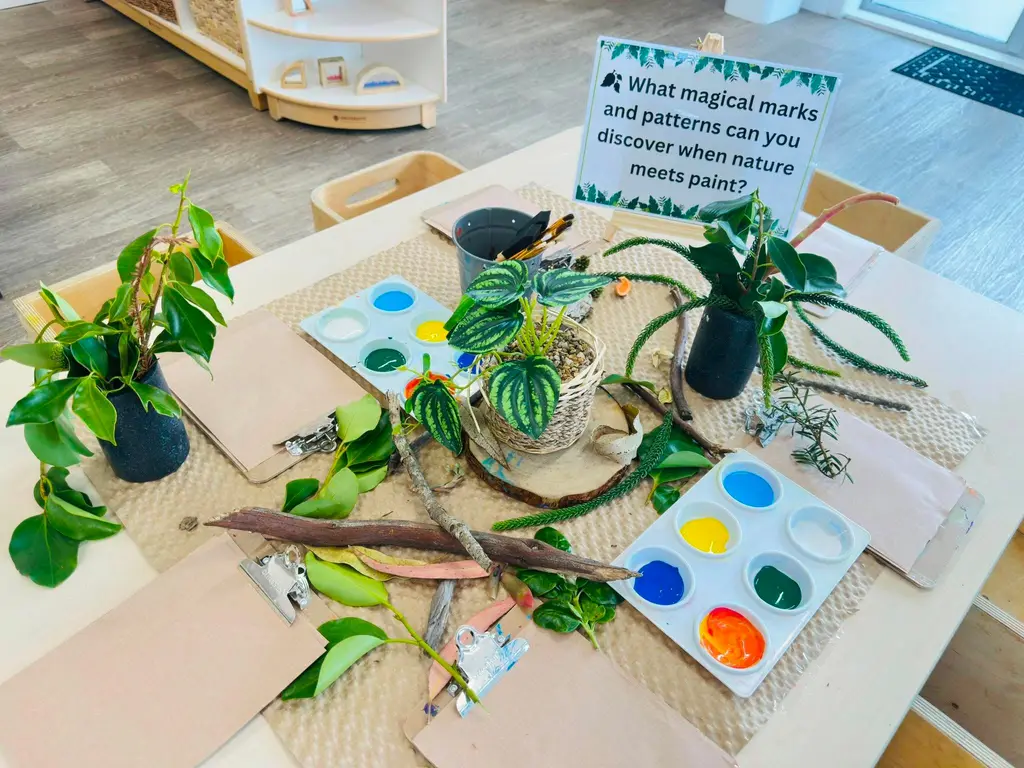 Leaves, natural materials, and paints arranged for an art activity