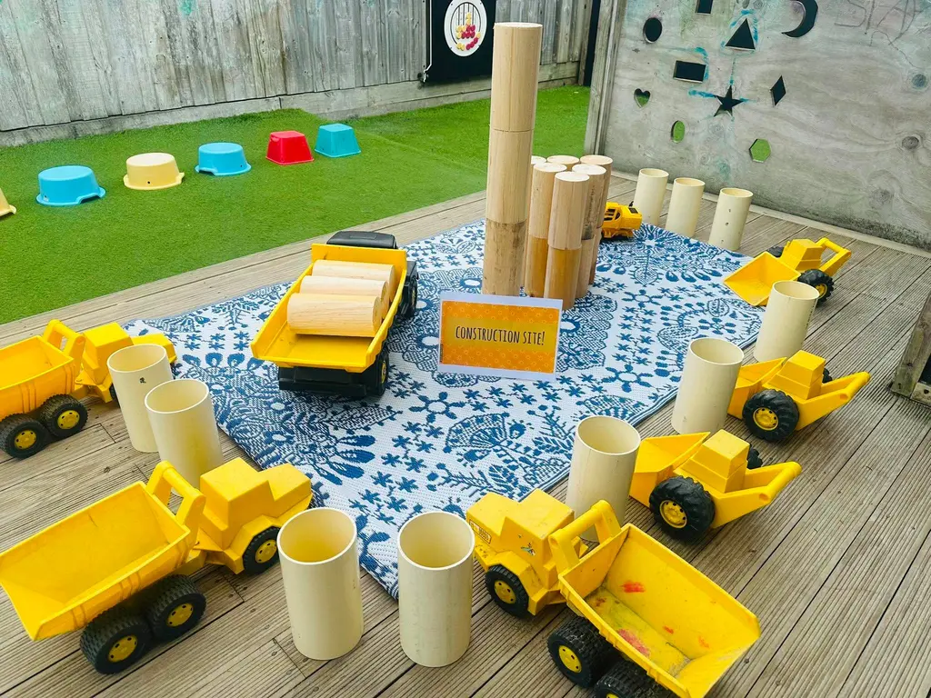 Toy trucks and construction materials on an outdoor play table