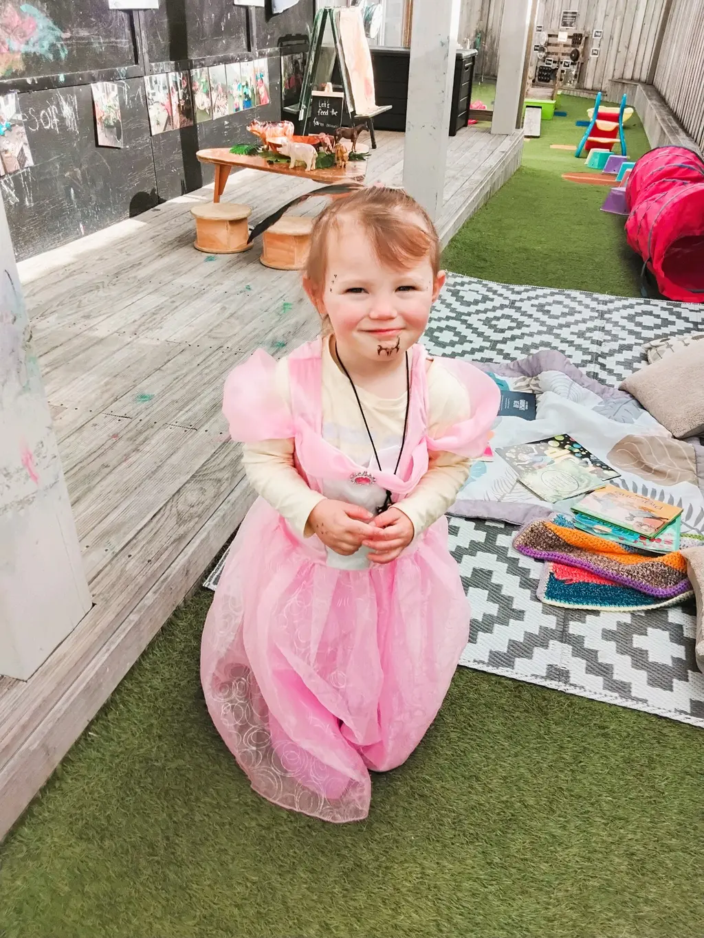 Child enjoying outdoor dress-up play in a pink costume