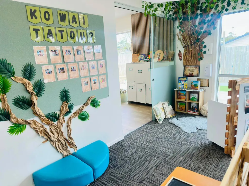 Quiet reading corner with cushions, books, and a tree display