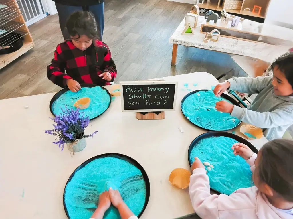Tamariki exploring blue sensory material at an activity table